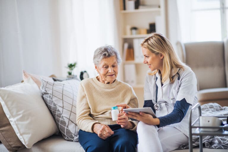 An elderly woman and her carer discuss the medication she needs to take