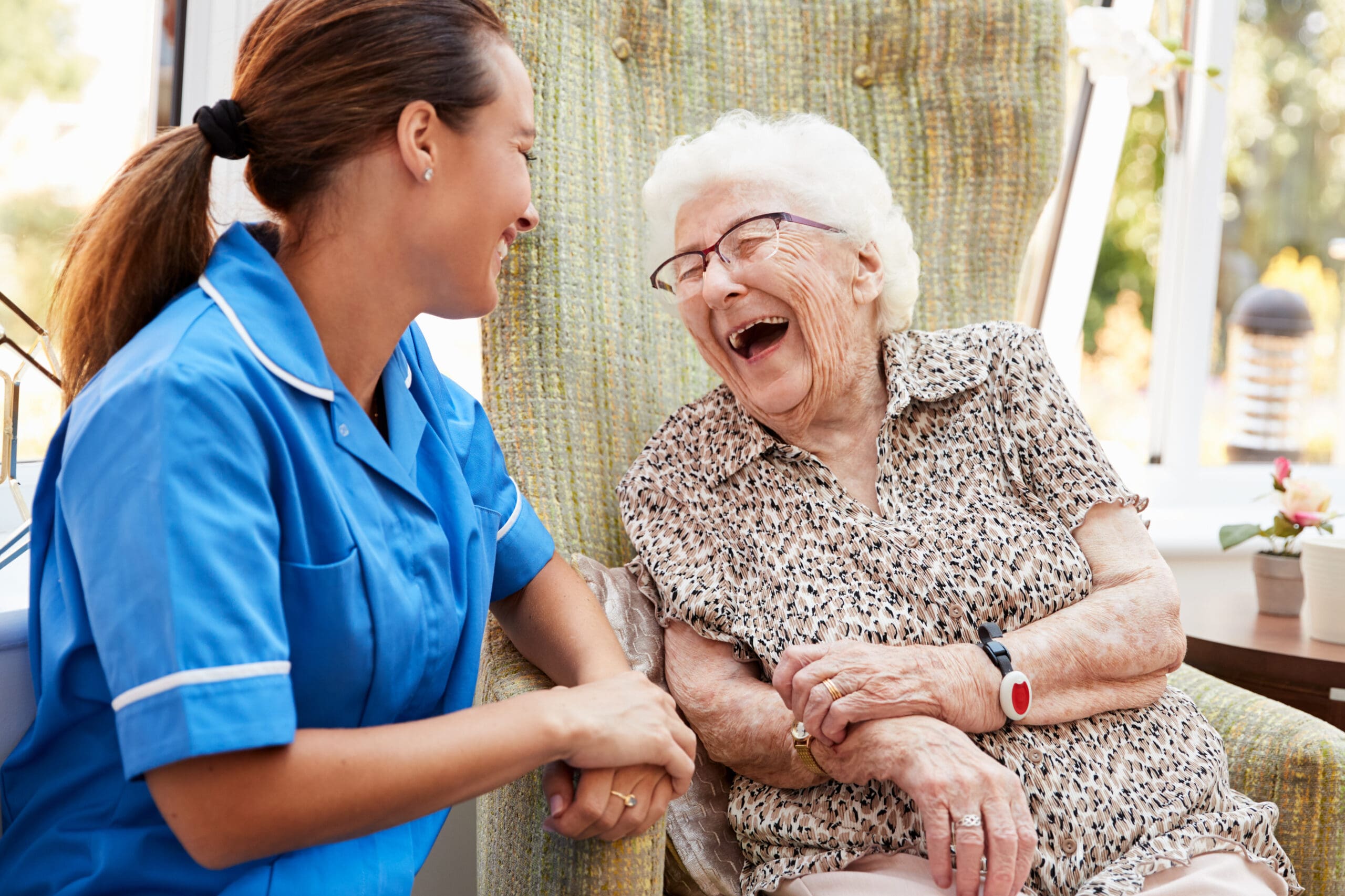 A carer and client laugh together