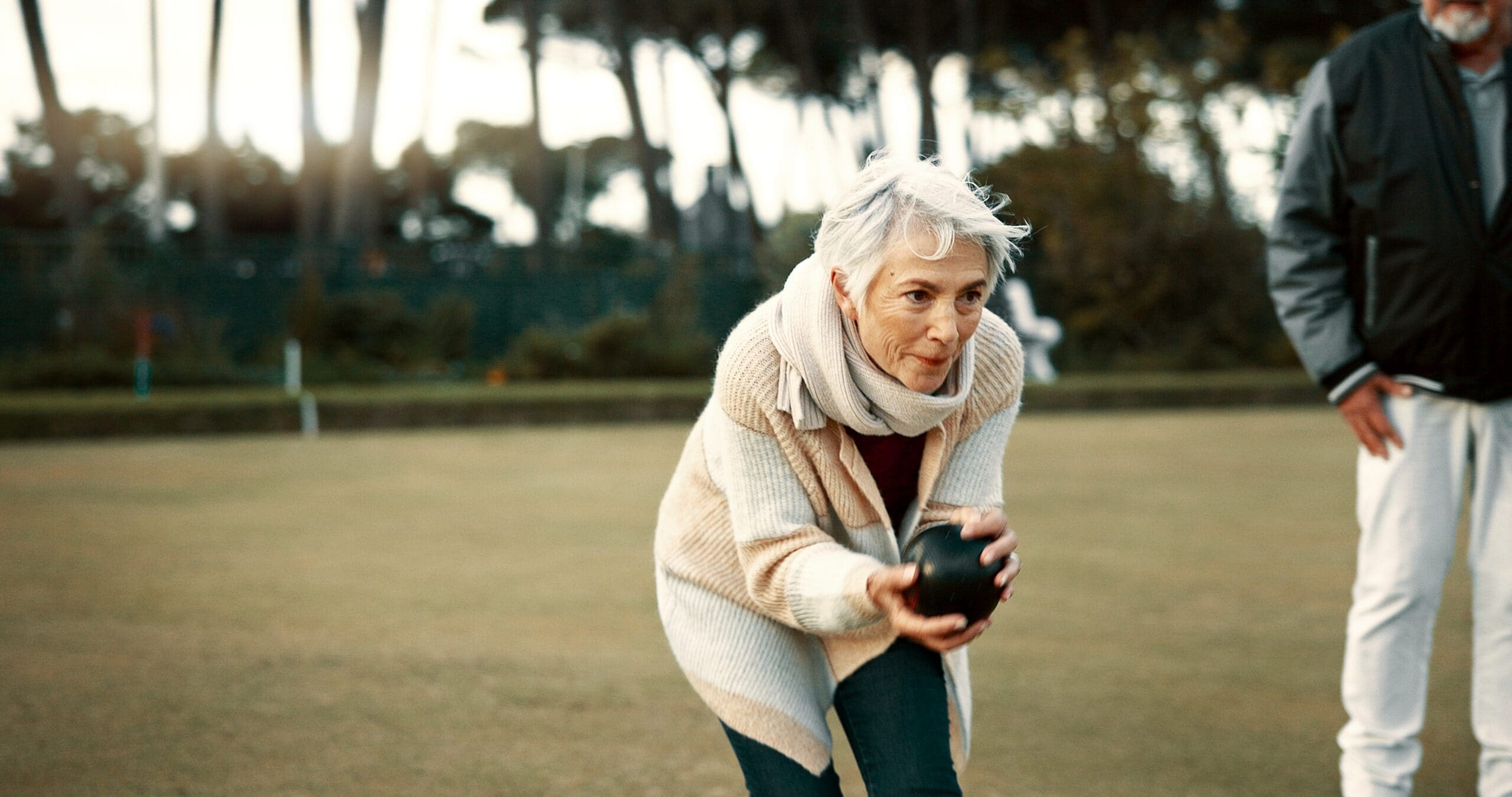 A woman takes her shot at bowling outside