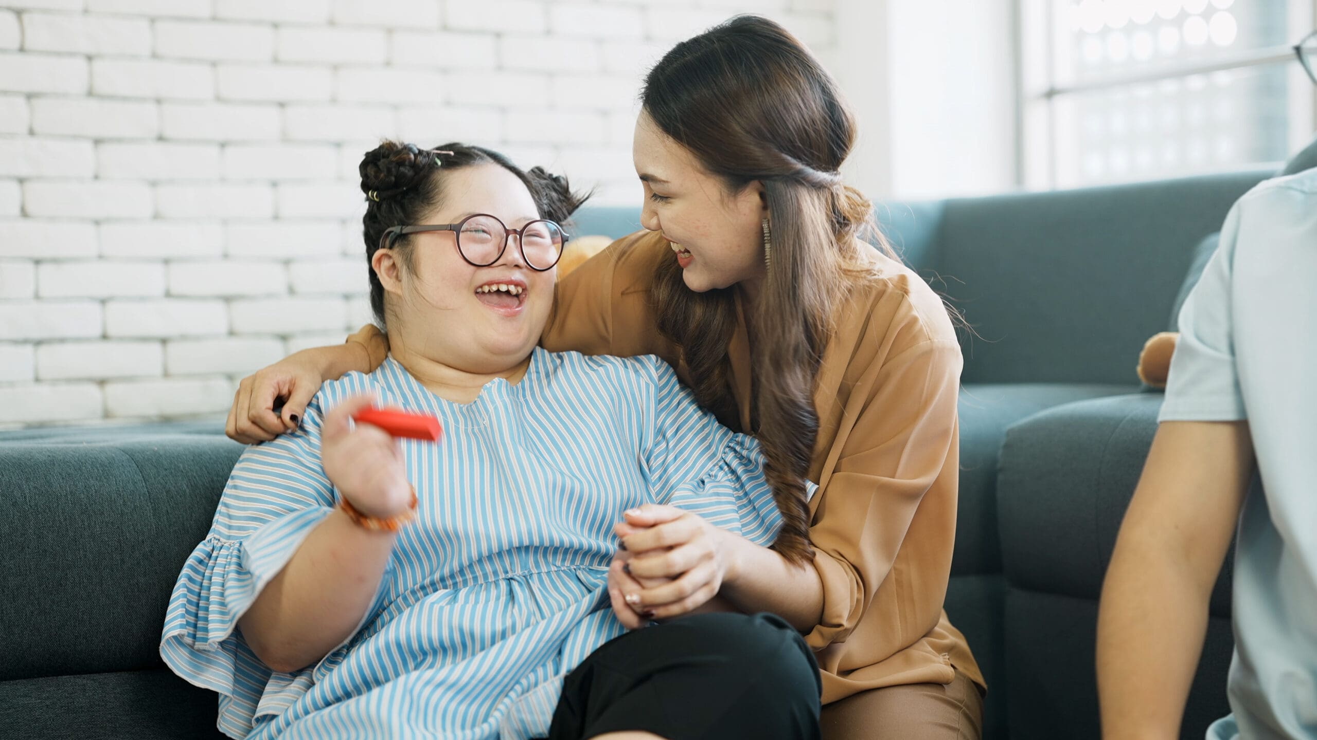 Two women laugh whilst in a hug