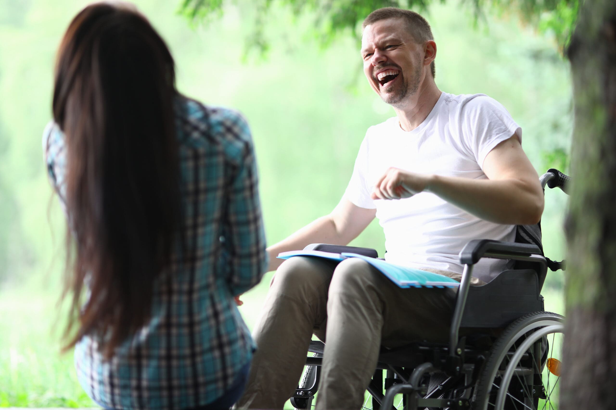 A man in a wheelchair laughs with his friend